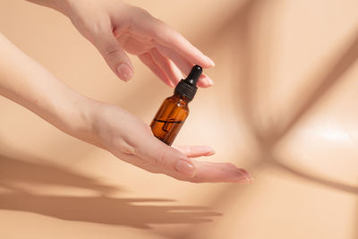 Cropped hand of woman holding bottle