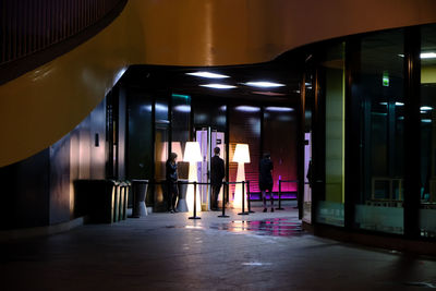 People walking in illuminated building