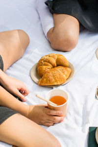 Croissants on eco paper plates and apple juice in an eco cup with a straw on a white blanket