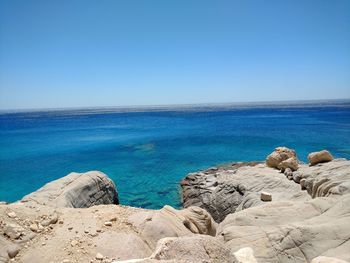 Scenic view of sea and rock formations against clear sky