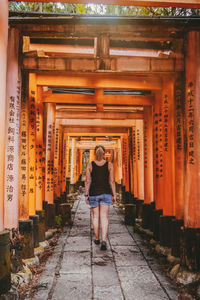 Full length portrait of young woman in temple against building