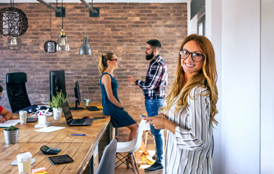 Smiling businesswoman looking at camera in office