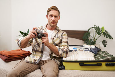Portrait of senior man using mobile phone while sitting on sofa at home