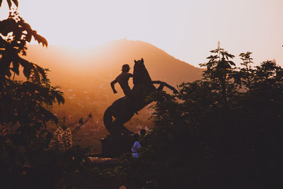 Statues against mountains during sunset