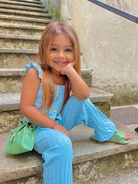 Portrait of a smiling girl sitting outdoors