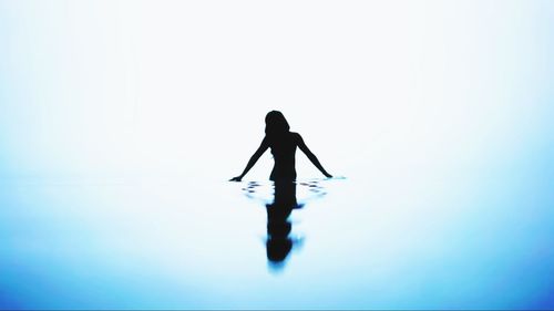 Silhouette person standing against blue background