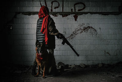 Man standing against wall at night