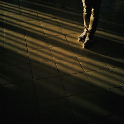 Low section of person standing in the dark