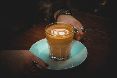 Person holding coffee cup on table