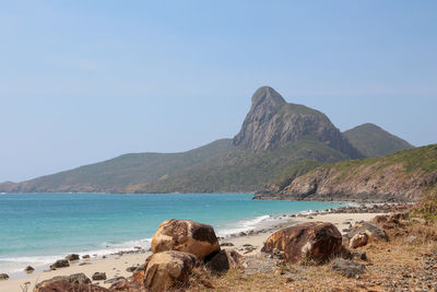 Scenic view of sea and mountains against clear sky