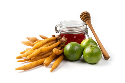 Close-up of lemons in jar against white background