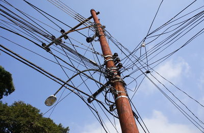 Low angle view of electricity pylon against sky