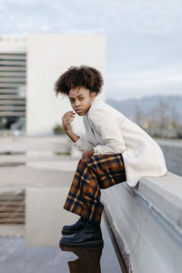 Portrait of boy standing against built structure