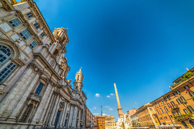 Low angle view of statue of building against blue sky