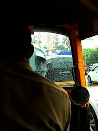 Rear view of man seen through car window