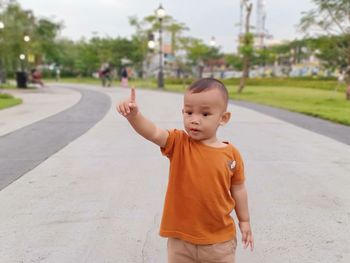 Portrait of asian boy standing on park road