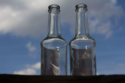 Low angle view of glass bottles against sky