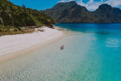 Drone view of couple at beach on sunny day