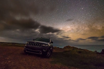 Car on wet road against sky at night