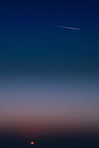 Low angle view of vapor trail in sky during sunset