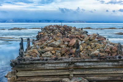 Stack of stones on beach against sky