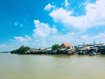 Scenic view of sea by buildings against sky