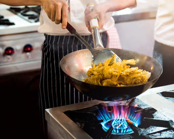 Midsection of man preparing food in kitchen