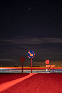Road sign against clear sky at night