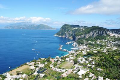 Aerial view of town by sea against sky