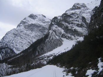 Low angle view of snowcapped mountains against sky