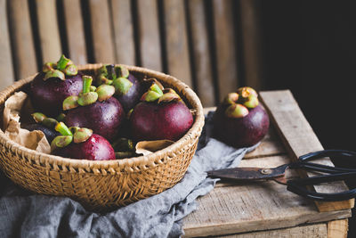 Close-up of purple mangosteen in basket on table