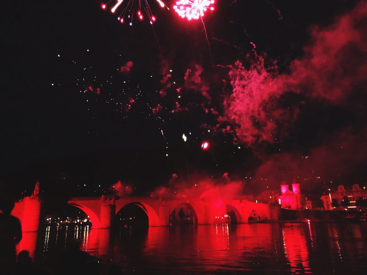 FIREWORK DISPLAY OVER RIVER AT NIGHT