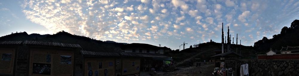 Houses in town against cloudy sky