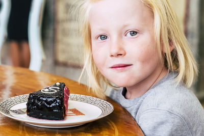 Close-up portrait of boy having dessert at table