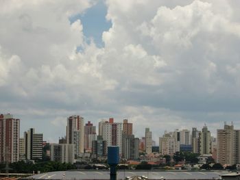 View of cityscape against cloudy sky