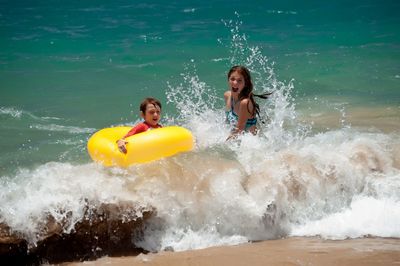 Siblings enjoying in sea