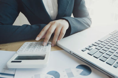 Midsection of man using laptop on table