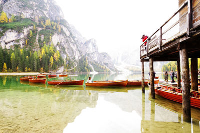 Boats in lake against mountain range