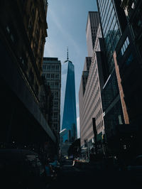 Cars on road amidst buildings in city against sky