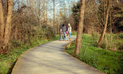 Rear view of people walking on footpath