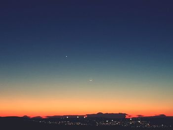 Scenic view of city against clear sky at sunset