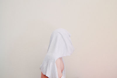 Towel over figurine against beige background