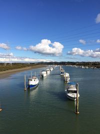 Boats moored in sea against blue sky