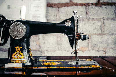 Close-up of sewing machine against wall