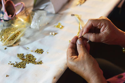 Cropped hands of man making jewelry on table