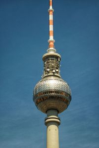 Low angle view of communications tower against blue sky