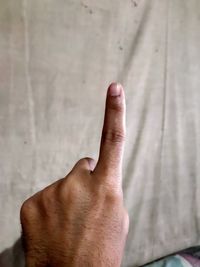 Close-up of human hand against wall