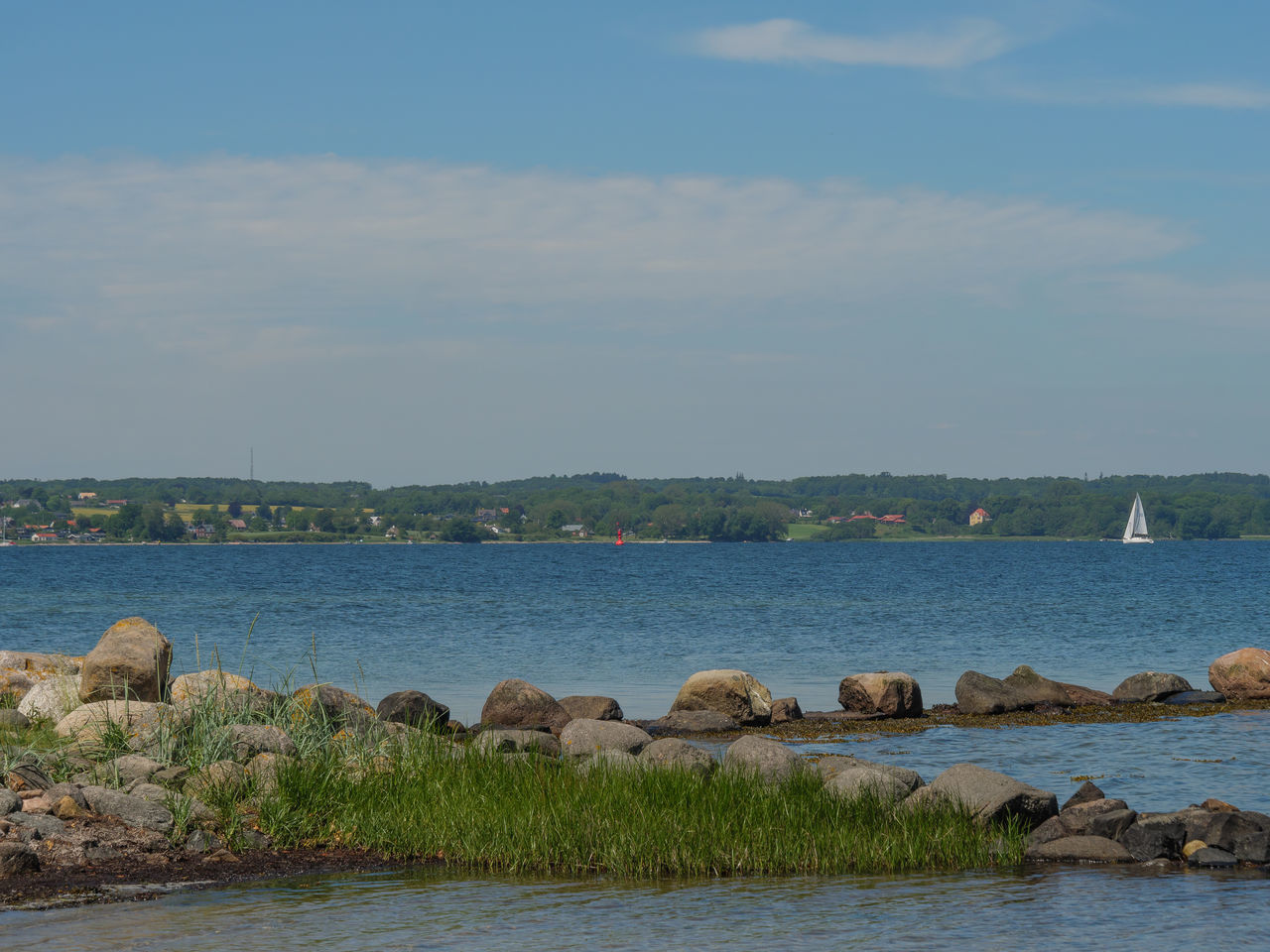 ROCKS BY SEA AGAINST SKY