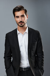 Young man standing against gray background