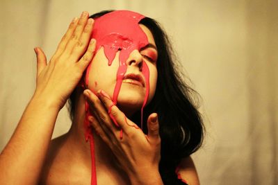 Young woman with red paint on her face